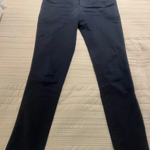Mörkblåa chinos fr Selected Homme strl 28/30 - Mörkblåa chinos från Selected Homme i storlek 28/30. Det är slim fit och till herr.