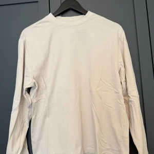 Beige långärmad tröja New Garments - Säljer en stilren beige långärmad tröja från New Garments i 100% bomull. 