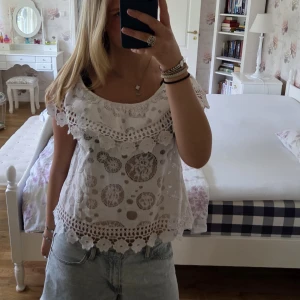 Vit blus med spets och broderi - Superfin vit blus med offshoulder och broderade spetsdetaljer. Blusen är mycket luftig och lätt, passar perfekt till varma dagar. Blusen är one size och skulle kunna passa vem som helst. Aldrig använd och därför säljer jag denna✨️.                                           Pris kan diskuteras och betalning sker via swish.