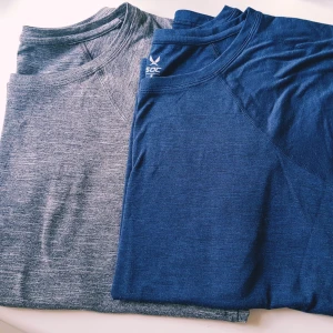 2-pack SOC t-shirts blå & grå strl M - Två snygga t-shirts från SOC i storlek M, en i marinblått och en i melerad grå. Båda har rund hals, kort ärm och är tillverkade i ett mjukt, lätt material som andas – perfekt för träning eller chill. Enkel, sportig design utan tryck.  Grå- helt & fint skick  Blå- helt skick dock små noppror