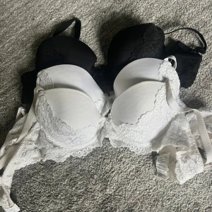 3-pack spetsiga bh:ar svart & vit B65 - Säljer tre snygga bh:ar i storlek B65, en i svart och 2 i vit. Båda har vadderade kupor och är dekorerade med spets. Perfekt för dig som gillar både basic och lite mer detaljer.