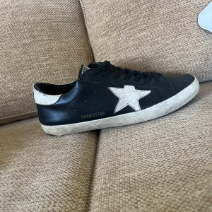Golden Goose svarta sneakers med stjärna - Ett par feta Goolden goose i st 42. Do. Är svarta och vita.  Man får med både dust bag och låda. Dom är kanska bra skick har tagit hand om dom och har släppt lite i sulan. Hör av er vid frågor och bilder. Priset är inte hugget i sten😁