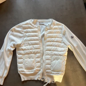 Moncler cardigan  - ❣️INTRESSEKOLL, kom med bud❣️på min fina moncler cardigan i strl 1 . Den har defekter som ni ser på bilderna. Går säkert o försöka få bort i tvätten. Vill ni se mer detaljer på jackan är de bara o skriva som t.ex lappar, dragkedjor, knappar. Lappen i nacken är av men bara att sy på men jag har inte orkat göra det bara. Köptes på plick förra året för 4000, kan inte garantera att den är äkta men hon jag köpte av visade kvitto och garanterade att den va äkta.🥰🥰skriv för funderingar 