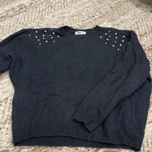 Mörkblå stickad tröja med pärlor H&M - Mysig mörkblå stickad tröja från H&M med långa ärmar och snygga pärldetaljer på axlarna. Stretchigt material så trots att det är barnstorlek så har den en större passform. Passar mig som bär storlek S