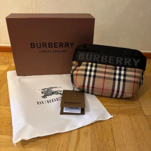 Burberry midjeväska - Säljer en helt ny och oanvänd midjeväska från burbery med färgen svart och beige. Låda oxh dustbag tillkommer.