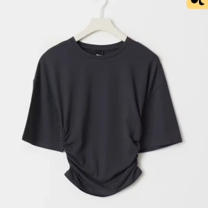 Svart t-shirt med snörning - Snygg svart t-shirt med korta ärmar och cool snörningsdetalj i sidan som ger en unik twist. T-shirten har en avslappnad passform och rund halsringning, perfekt för en stilren och trendig look.