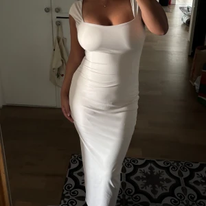 Beige klänning  - En fin beige klänning med slits där bak. Klänningen har en underklänning som sitter fast som gör att den inte går att se igenom. 