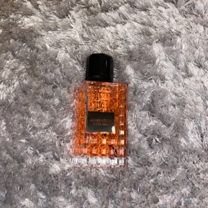 Admiration Eternal parfymflaska - Snygg parfymflaska från Admiration Eternal med ett rutmönstrat, transparent glas i orange ton och svart, åttakantigt lock. Flaskan har en lyxig känsla och sticker ut med sin unika design. Perfekt för dig som gillar att ha snygga detaljer på hyllan.