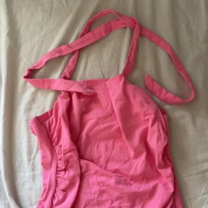 Rosa topp från SHEIN - Säljer en söt rosa topp med knytband i nacken. Perfekt för varma dagar och somriga vibes. Materialet känns mjukt och lätt mot huden. Använd några få gånger, inga slitage eller liknande. Superfin💕