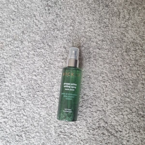 Hickap Preppy Prime Setting Spray - Grön genomskinlig flaska med silvrig spraypump. Setting spray med matt finish som håller sminket på plats, motverkar glans och minskar synliga porer. Skyddar mot föroreningar och UV-ljus, återfuktar och lugnar huden. 100% vegansk och passar alla hudtyper. Endast testad en gång!