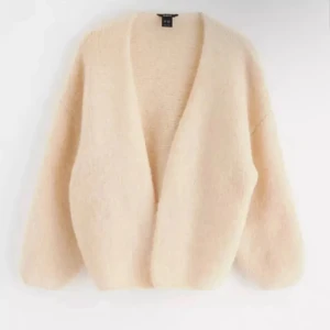 Beige fluffig kofta från H&M - Nästintill oanvänd  beige kofta från Lindex med oversized passform och djup v-ringning. Perfekt för lager-på-lager och har långa ärmar med en avslappnad siluett. Är en M/L men upplevs som en S/M 🥰