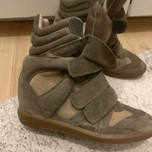 Isabel Marant wedge sneakers beige - Coola wedge sneakers från Isabel Marant i beige mocka och skinn. Perfekta för dig som vill ha en cool men clean look.