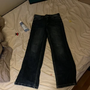 Mörkblå bootcut jeans Kappahl 158 - Snygga mörkblå jeans från Kappahl i storlek 158. Modellen har bootcut-ben och klassisk femficksdesign. Jeansen är tillverkade i denim med lite stretch för skön passform. Perfekta för dig som gillar en tidlös look med lite utsvängda ben.