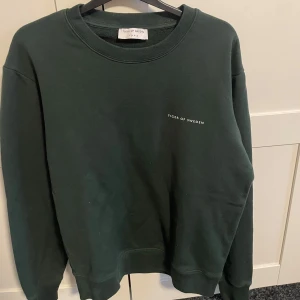 Tiger of Sweden tröja - En stilren mörkgrön sweatshirt från Tiger of Sweden med  logga på bröstet. Materialet är mjuk bomull som känns skönt mot huden. Knappt använd! Kom med bud!