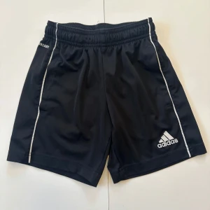 Svarta adidasshorts till barn strl 116-122 - Storlekslappen är avklippt men passar 116-122. Smal tight midja  Shorts Kortbyxor  Barn Adidas Byxor