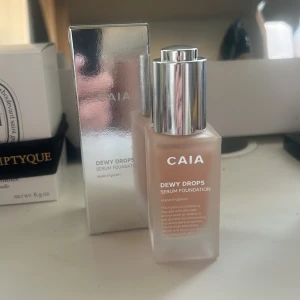 CAIA Dewy Drops Serum Foundation 20C - CAIA Dewy Drops Serum Foundation i nyansen 20C. Kommer i en snygg frostad glasflaska med silvrig pump. Innehåller vitamin E och glycerin för återfuktning och glow. Perfekt för dig som vill ha en naturlig och fräsch finish på huden. Bara testad två gånger, var lite fel färg för mig!💕