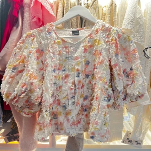 Blommig volangblus från Gina Tricot - Superfin blus med voluminösa puffärmar och struktur i tyget. Blusen är vit med blommigt mönster i rosa, gul och blå. Den har rund halsringning och är täckt av små volanger som ger en cool och unik look. Perfekt för dig som gillar färg och statement-plagg. Nypris 599 säljer för 300☺️