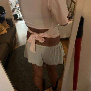 Ljusrosa croppad t-shirt med knyt - Snygg ljusrosa croppad t-shirt med korta ärmar och knyt i ryggen som ger en öppen rygg🩷sl xl men är liten i stolek så sitter som L/M