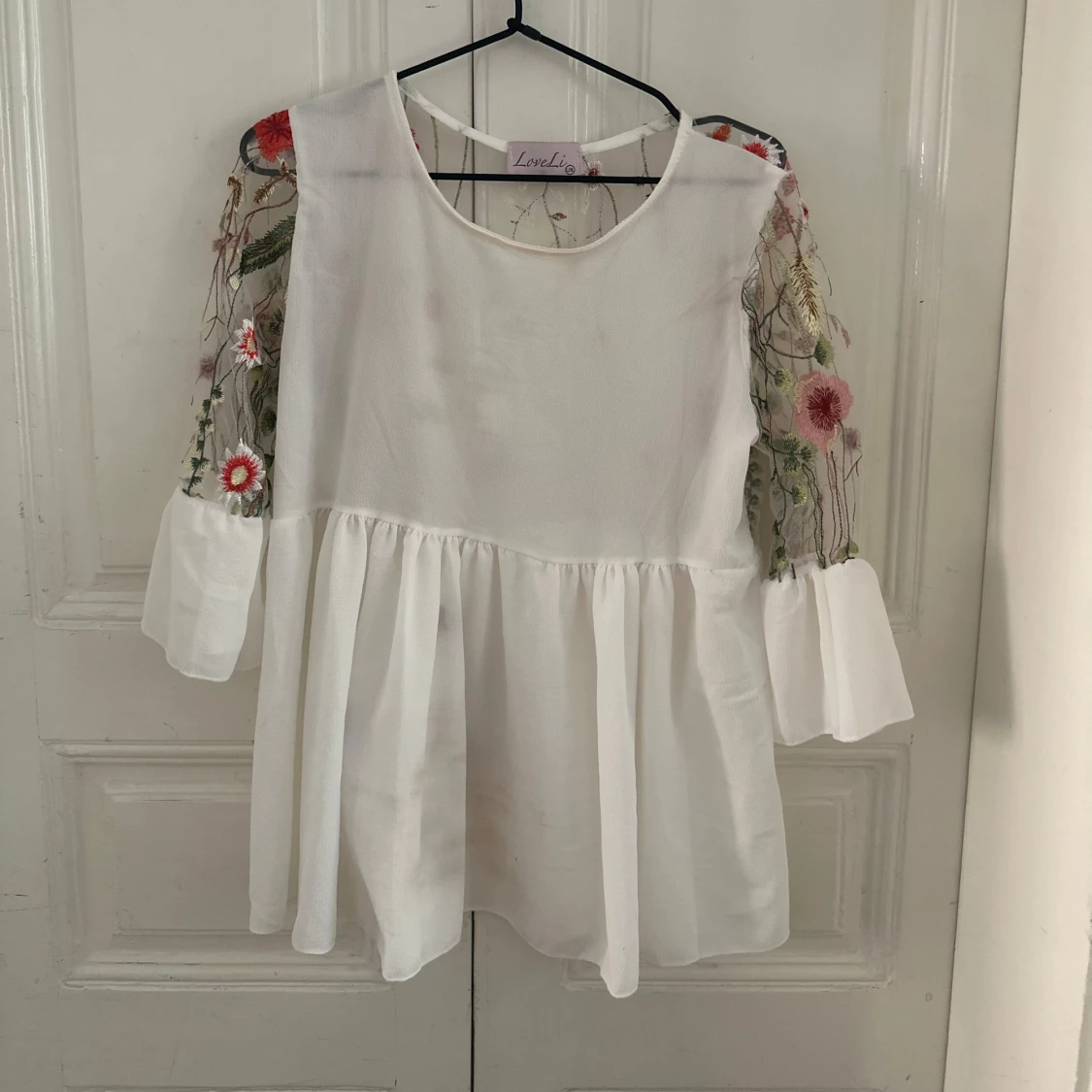 Vit blus med broderade blommor