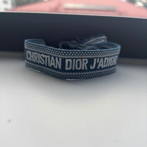 Blå Christian Dior J'Adior armband - Helt ny och oanvänd. Justerbar så den passar alla oavsett storlek. Billigare vid köp av fler