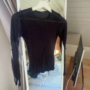 Svart långärmad  - Snygg svart långärmad tröja med rund hals. Modellen är slim och passar perfekt till jeans eller kjol. Materialet är mjukt och stretchigt, vilket gör den skön att bära hela dagen. Enkel och stilren design som funkar till många olika outfits.