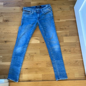 Blå skinny jeans från Replay - Snygga blå skinny jeans från Replay med klassisk femficksdesign och ljusa slitningar. Jeansen har normal midja och smal passform hela vägen ner. Materialet är mjukt jeans med stretch för extra komfort. Perfekta till sneakers eller boots. Har själv testat och funkar till kille 