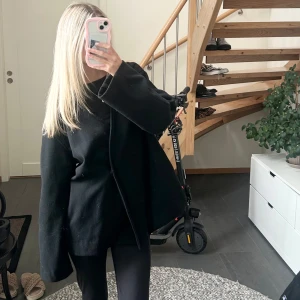 Svart kappa - Säljer en svart kappa som saknar band. Från Bikbok i mycket bra skick då den inte är använd så mycket. Perfekt nu till hösten!!