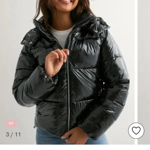 Svart pufferjacka med huva - Snygg svart pufferjacka med glansig finish och huva. Jackan har dragkedja framtill och breda, quiltade sektioner som ger en cool look. Perfekt för kalla dagar och enkel att matcha med jeans eller hoodie. Jackan har lång ärm och en loose passform. Jackan är använd ett fåtal gånger och är i storlek S. Bilderna är lånade men vid ett intresse så kan jag skicka bild hur den ser ut på! Skickas inom en dag o du står för frakten💓 Ursprungliga pris är 799 kronor nypris är 400 kronor