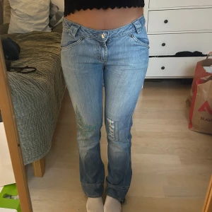 Low waist jeans med paljetter - Unika lågmidjade flare/bootcut jeans med paljett detaljer på bakfickan och vid knäna. ”Kristall” som knapp. Köpta i Japan! Märket Comely. Storlek: M. Men skulle säga att de passar S också. 40 cm tvärs över vid midjan.