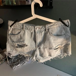 Ljusablåa jeansshorts med slitningar - Säljer ett par ljusblå jeansshorts eftersom de ej kommer till användning! Storlek 40!