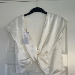 Champagnefärgad/vit topp i satin XS - Fin topp från Zara i xs som aldrig använts.