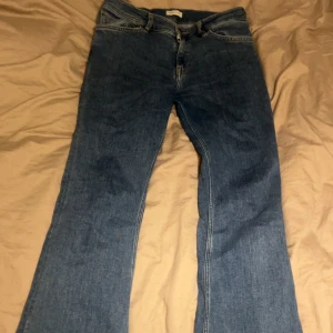 Blå bootcut jeans från Gant - Snygga blå jeans från Gant med klassisk bootcut passform och fem fickor. Jeansen har en normal midja och är tillverkade i slitstarkt denimtyg med tydliga sömmar. Perfekta för dig som gillar en lite vidare siluett nertill och vill ha en tidlös look.