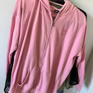 Rosa hoodie med HOPE-tryck  - Säljer en chill rosa hoodie från Cubus i storlek XL. Tröjan har dragkedja, huva och fickor framtill. På ryggen står det HOPE i stort tryck med ett hjärta. Mjuk och skön, perfekt för att mysa eller hänga med kompisar.
