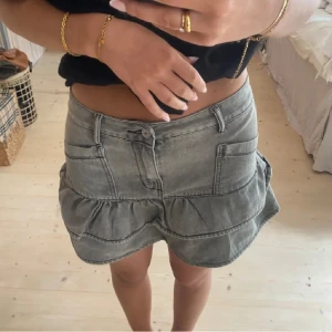 Grå jeanskjol med volang - Första bilden e lånad! Kjolen e köpt på Plick och första bilden e från den jag köpte ifrån, fins tyvärr ingen lapp på men skulle säga att den passar som en S säljs pga används bara ibland 