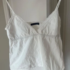 Vit linnetopp med spets från Brandy Melville - Säljer en söt vit linnetopp från Brandy Melville med tunna axelband och spetsdetaljer. Jättefint skick. One size men typ S/M💘