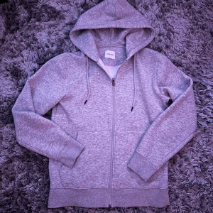 Grå zip hoodie - Säljer en helt vanlig grå zip hoodie från Jack&jones. Storlek xs. Hör av dig vid frågor eller funderingar.
