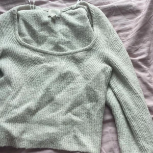  stickad  tröja - Supermjuk beige stickad tröja med ribbad struktur och fyrkantig urringning. Långärmad och croppad modell som är perfekt att styla med höga jeans eller kjol. Enkel men ändå trendig vibe för dig som gillar stilrena plagg.