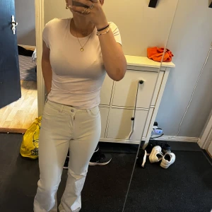 Vita bootcut jeans med hög midja - Säljer ett par vita jeans med bootcut-modell och hög midja. Byxorna har klassisk femficksdesign, raka ben som blir vidare nertill och stängs med knapp och dragkedja. Perfekta för dig som gillar en clean och fräsch look. Dem är i storlek 40/38 ifrån HM. De är lång på mig jag är 164