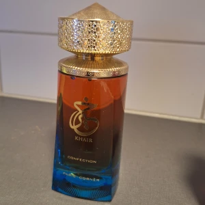 Khair Confection Paris Corner parfym - Khair Confection från Paris Corner är en parfym för kvinnor med en lyxig flaska i blått och bärnstensfärgat glas samt en detaljerad guldig kork. Doften är ljuv, med inslag av vanilj, frukt, pudriga och träiga toner samt en hint av vatten. Perfekt för dig som gillar unika och eleganta dofter.(Enbart testad)