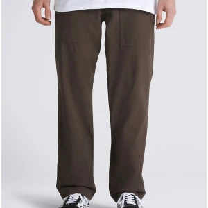 Fatigue Loose Tapered Pant i färgen Turkish coffee från Vans - Fatigue Loose Tapered Pant i färgen Turkish coffee från Vans är ett bekvämt och stilrent alternativ för vardagsbruk. Dessa byxor är gjorda av en mjuk och hållbar bomullsblend och har en avslappnad passform som är perfekt för komfort hela dagen.  Aldrig använda med lappen kvar. Strl 32 (jeans-storlek)