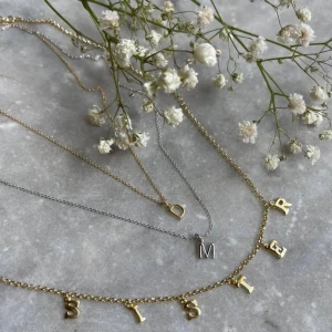 Guldhalsband SISTER Peg & Penny - Superfint halsband i guld från Peg & Penny x Guldfynd med bokstäverna SISTER som hängande berlocker. Kedjan är tunn och elegant, perfekt för att ge en personlig touch till din stil. Kommer i original ask. Alltså bara det halsbandet som man kan se på bild två, halsbandet är gjort i äkta silver men har tyvärr ej asken kvar men jag skickar med en ask från guldfynd🤍🤍