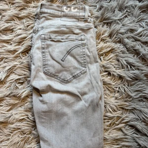 Dondup George jeans - Snygga ljusgrå jeans från Dondup, tillverkade i Italien. Modellen har klassisk femficksdesign, raka ben och diskreta sömdetaljer på bakfickorna. De är i storlek 33 men de är väldigt små i storleken så om du har w33 så sitter de skinny på dig men om du har storlek w31 så passar de som slim fit. De är dock väldigt stretchiga i storleken så de passar de flesta från w31 till w33. 10/10 skick nästan aldrig använda och inga defekter. Bara att höra av sig vid minsta fundering!