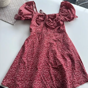 Blommig klänning - Röd blommig klänning i utmärkt skick. Kolla gärna in mina andra annonser och köp gärna bundle!