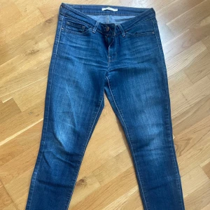 Levi's 711 Skinny jeans blå, stl 27 - Säljer ett par Levi's 711 Skinny jeans i klassisk blå tvätt. Jeansen har fem fickor, smal passform och normal midja. Väldigt sparsamt använda.