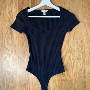 Svart T-shirt body - Säljer den här svarta bodyn från HM då jag sällan använt den.