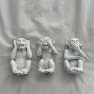 Vita apor prydnadsfigurer set om tre - Tre coola prydnadsfigurer i form av apor som gestaltar 'inte höra, inte se, inte tala'. De är målade i vitt med lite slitna detaljer och har en charmig, handgjord känsla. Perfekt som dekoration i rummet för en personlig touch.