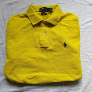 Ralph Lauren piké  - Tjo gubbar! En fin ny Ralph Lauren piké i väldigt bra skick. Gul med märket i mörkblått. Passar Alla storlek M. Kolla gärna profilen för mer Ralph Lauren kläder. Följ gärna också 😉. Ha de göttttttt!!!