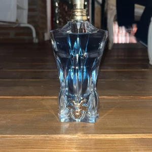 Jean Paul Gaultier Le baou parfym - Ikonisk parfymflaska formad som en manlig torso i genomskinligt glas med blått innehåll. Flaskan har en metallisk detalj framtill och en guldfärgad spraytopp. En klassiker med modern och stilren design. Det är en 120 ml ny pris är cirka 1000kr