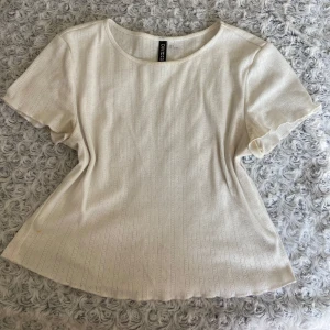 Vit blus från H&M  - Söt vit blus från H&M Divided i storlek S. Toppen har korta ärmar, rund halsringning. Jättesnyggt till jeans eller kjol för en fräsch look.