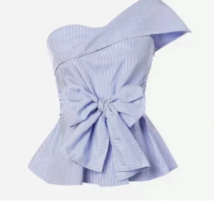 Randig offshoulder topp med rosett - Superfin blåvit randig topp med en stor rosett framtill och asymmetrisk offshoulder-skärning. Toppen har peplumformad nederdel och smala ränder för en fräsch look. Perfekt för dig som vill sticka ut med en unik och trendig stil.